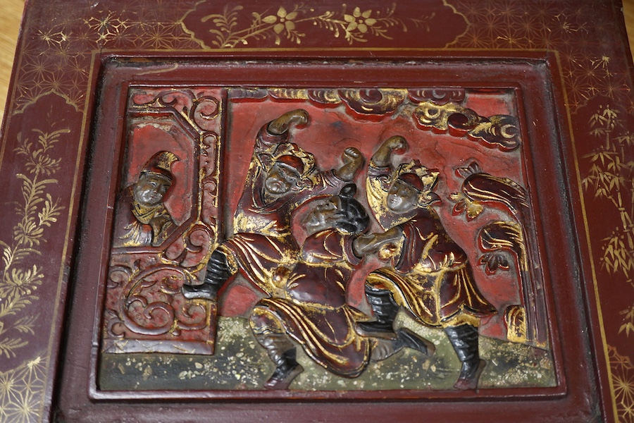 A Chinese lacquered box decorated with relief figures, 33cm wide